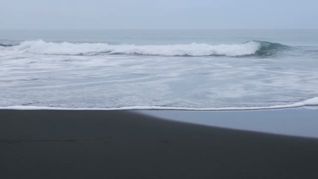Ocean waves on black sand